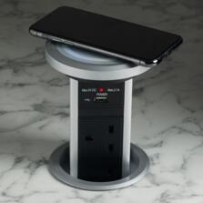 Motorised pop up socket set in to kitchen worktop showing wireless qi charger charging mobile phone
